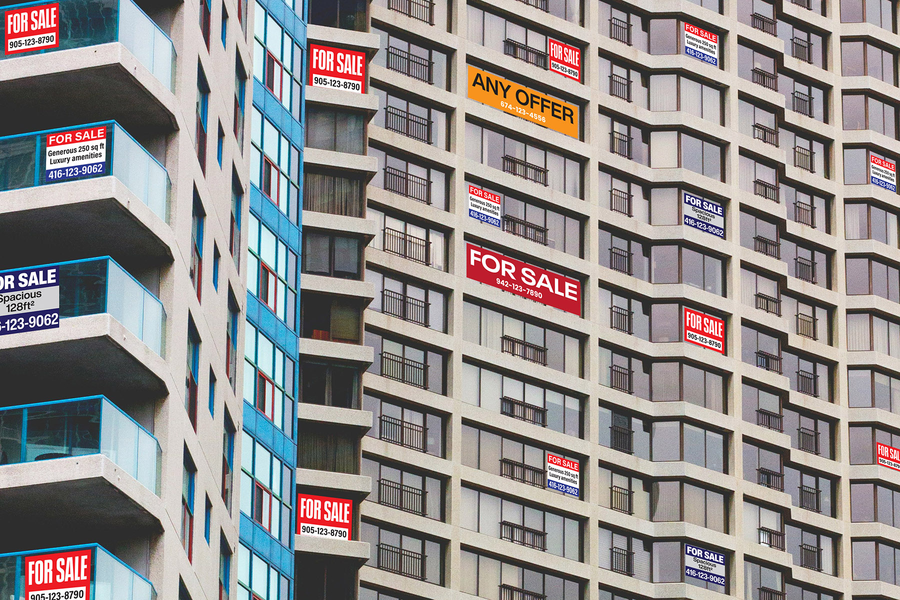 A condominium building covered in signs that say for sale.
