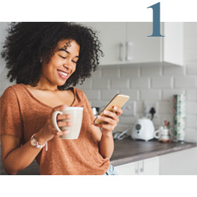 woman scrolling on phone while standing in kitchen