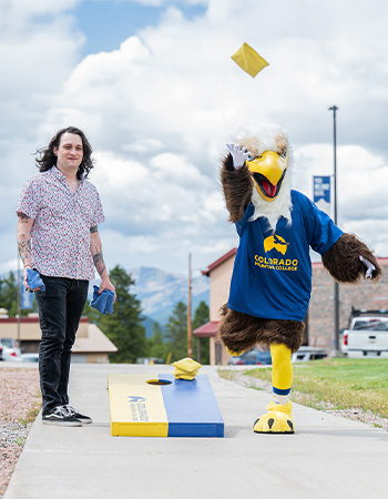 Swoop playing cornhole with a CMC student.