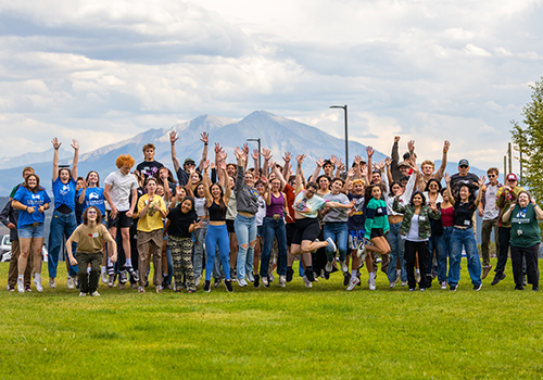 CMC students jumping together.